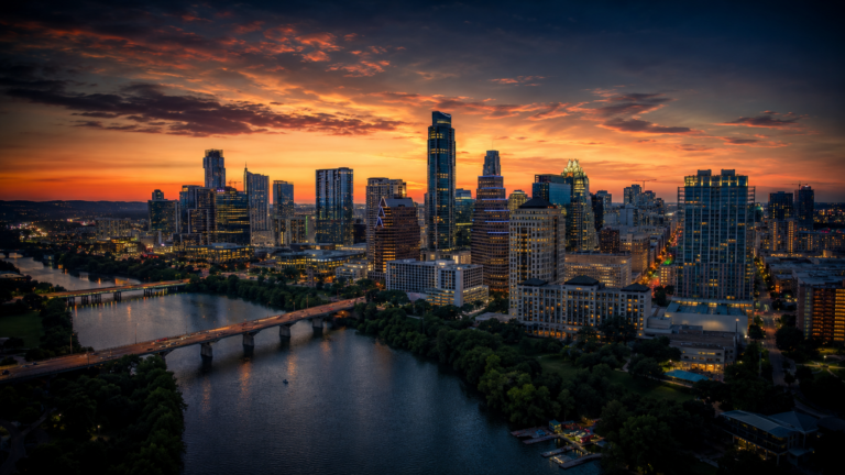 Austin Texas skyline aerial view at golden hour over Lady Bird Lake, April 2026 real estate market report by Shipman Partners Real Estate