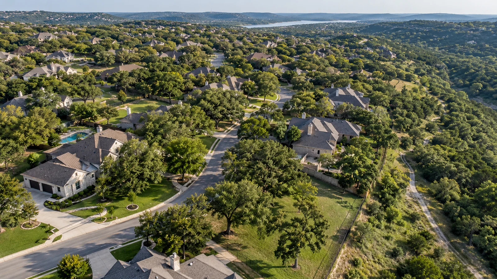 Aerial view of an established Southwest Austin neighborhood with mature trees and greenbelt